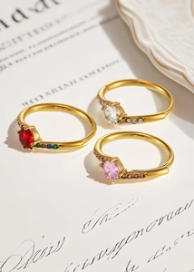 Detailed view of three stackable gold rings with colorful round zircon stones