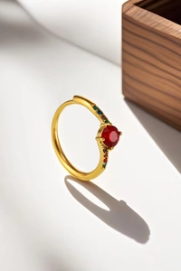Detail of 18K gold ring with pink zircon and multi-color stones in jewelry box