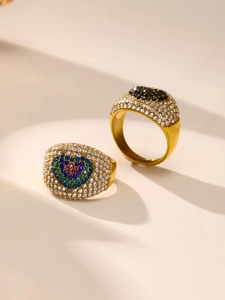 Details von vergoldeten Titanringen mit Zirkonia-Pflasterung und Herz-Motiv-Design