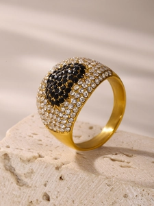 Detail eines vergoldeten Rings mit schwarz-weißen Zirkonia-Steinen in Pavé-Fassung