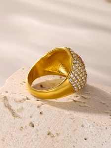 Detailansicht eines vergoldeten Rings mit Zirkonia-Mikropavé und rotem Edelstein