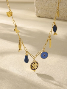 Detail of gold chain necklace featuring blue eye charms and multifaceted pendants