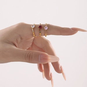 Three gold rings with pink, red, and white gems, featuring a crown crown design