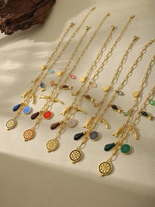 Detail of six gold-plated chains with colorful evil eye and mandala pendants
