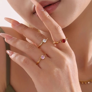 Elegant gold-plated crown rings with large colorful gemstones worn by a female model