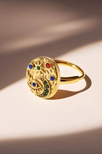 Detail of gold evil eye ring with star and moon charms and hammered texture finish