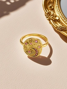 Detailed shot of vintage gold evil eye ring with crescent moon and pink zircon inlay