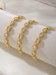 Dettaglio del bracciale geometrico placcato oro con cristalli su velluto bianco