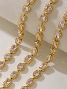 Dettaglio macro del bracciale dorato con zirconi geometrici e incastonatura halo