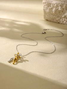 Detailed view of dual-tone abstract hugging figures pendant on gold titanium steel chain