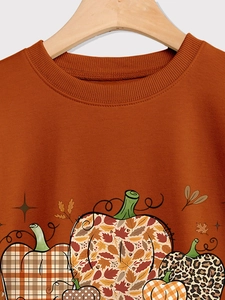 Detail of ribbed crewneck and pumpkin patchwork pattern on orange autumn sweatshirt