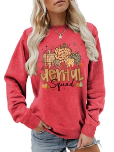 Detail of red Dental Squad sweatshirt featuring autumn-themed tooth patterns and soft cotton fabric