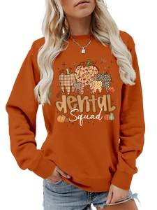 Close-up of orange long-sleeve sweatshirt featuring dental squad pumpkin tooth print