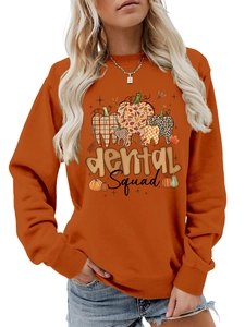 Detail of Dental Squad graphic print with plaid and leopard patterns on orange sweatshirt