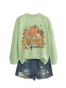 Detail of light green dental squad sweatshirt with pumpkin tooth graphic and denim shorts