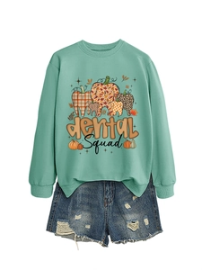 Detail of Dental Squad mint green sweatshirt featuring pumpkin and tooth graphic print