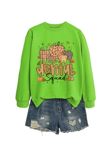 Detail of green long sleeve sweatshirt with dental squad pumpkin print and denim shorts