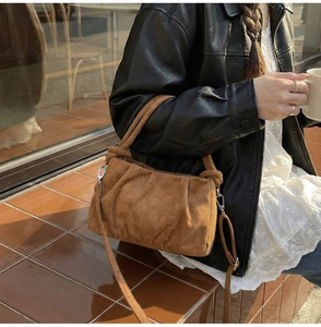 Close-up of caramel suede cloud bag with pleated texture and adjustable strap