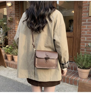Macro shot of vintage brown leather tote bag with toggle closure and contrast stitching
