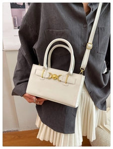 White minimalist tote bag with golden heart buckle shown on model for size perspective