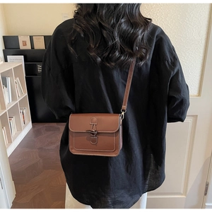 Detail of vintage brown leather tote bag showing toggle closure and white contrast stitching