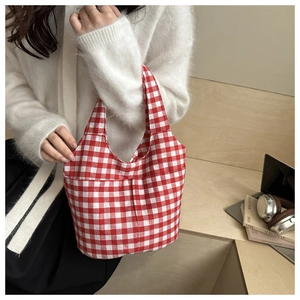 Detail of red and white gingham plaid tote bag with stylish pleated canvas design