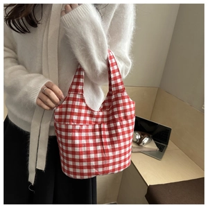 Detail of red and white checkered canvas tote bag with a seamless integrated handle