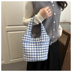 Detail of blue and white gingham canvas tote bag showing front pockets and texture