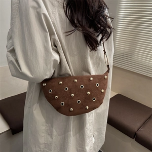 Brown suede crescent bag with gold studs and grommets in a retro bohemian style