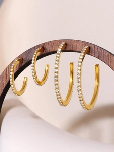 Detail of four graduated gold-plated titanium earrings with micro-pave cubic zirconia