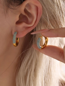 Detail of 18K gold plated hoop earrings with turquoise stones in a boho style