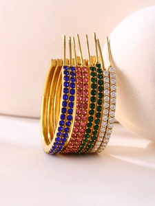 Macro view of gold hoop earrings featuring multi-color zircon inlay and polished finish
