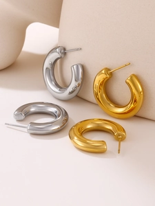 Présentation artistique de boucles d'oreilles créoles épaisses en C en métal poli or et argent