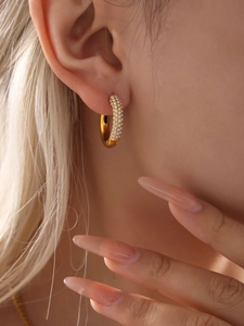 Close-up of gold stainless steel hoop earrings with 5A cubic zirconia on female model