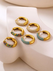 Close-up of gold-plated hoop earrings featuring white zircon and turquoise stones