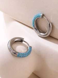 Detail of 4mm silver stainless steel huggie earrings with light blue zircon inlays