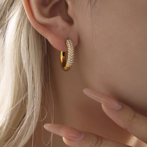 Elegant 4mm gold circle earrings with white zircon accents worn by a model in a close-up view