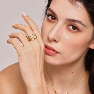 Vintage gold hollow round ring with sparkling crystals on female model's hand