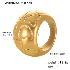 Macro view of gold stainless steel wide ring band with relief heart pattern details