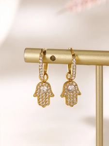 Detailed view of golden Hamsa Hand earrings with micro-paved cubic zirconia accents