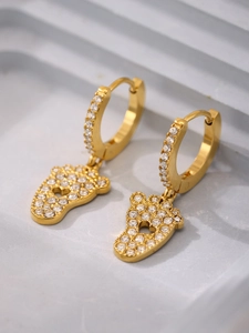 Λεπτομέρεια macro από επίχρυσα σκουλαρίκια 18k με κρεμαστά πατούσα αρκούδας και ζιργκόν