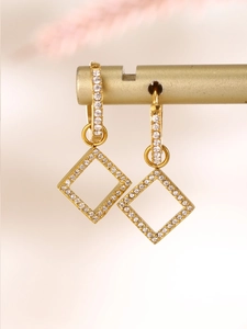 Detail view of 18k gold plated earrings with shimmering zircon pavé on square pendants