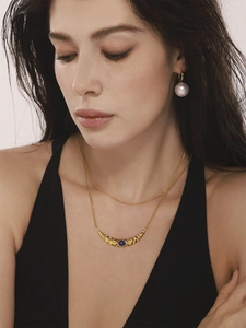 Détail du collier croissant doré avec lapis-lazuli et boucles d'oreilles perles élégantes
