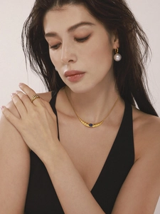 Gros plan du collier croissant d'or avec lapis-lazuli et boucles d'oreilles en perles