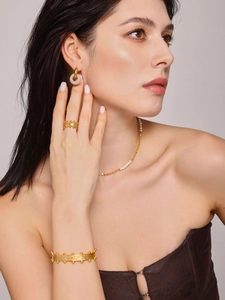 Close-up of vintage gold plated jewelry set featuring geometric rings and pearl details