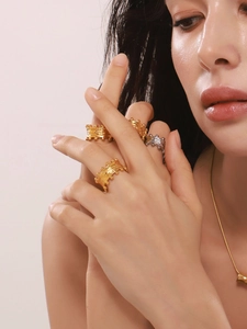 Detail of gold and silver textured rings with bead edges on model's hands