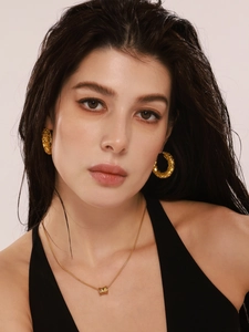 Detail of 18k gold plated earrings and necklace with unique scale texture on model