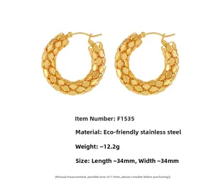 Close-up of 18K gold-plated stainless steel hoop earrings with scale-like texture details