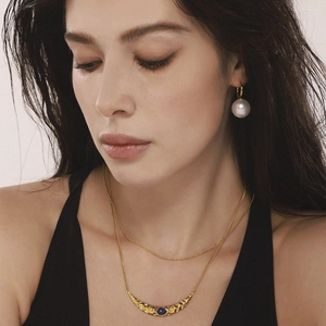 Mannequin portant collier croissant lapis-lazuli et boucles d'oreilles perles dorées