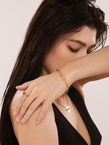 Nahaufnahme von elegantem 18k vergoldetem Armband und Ring-Set mit schwarzem Edelstein